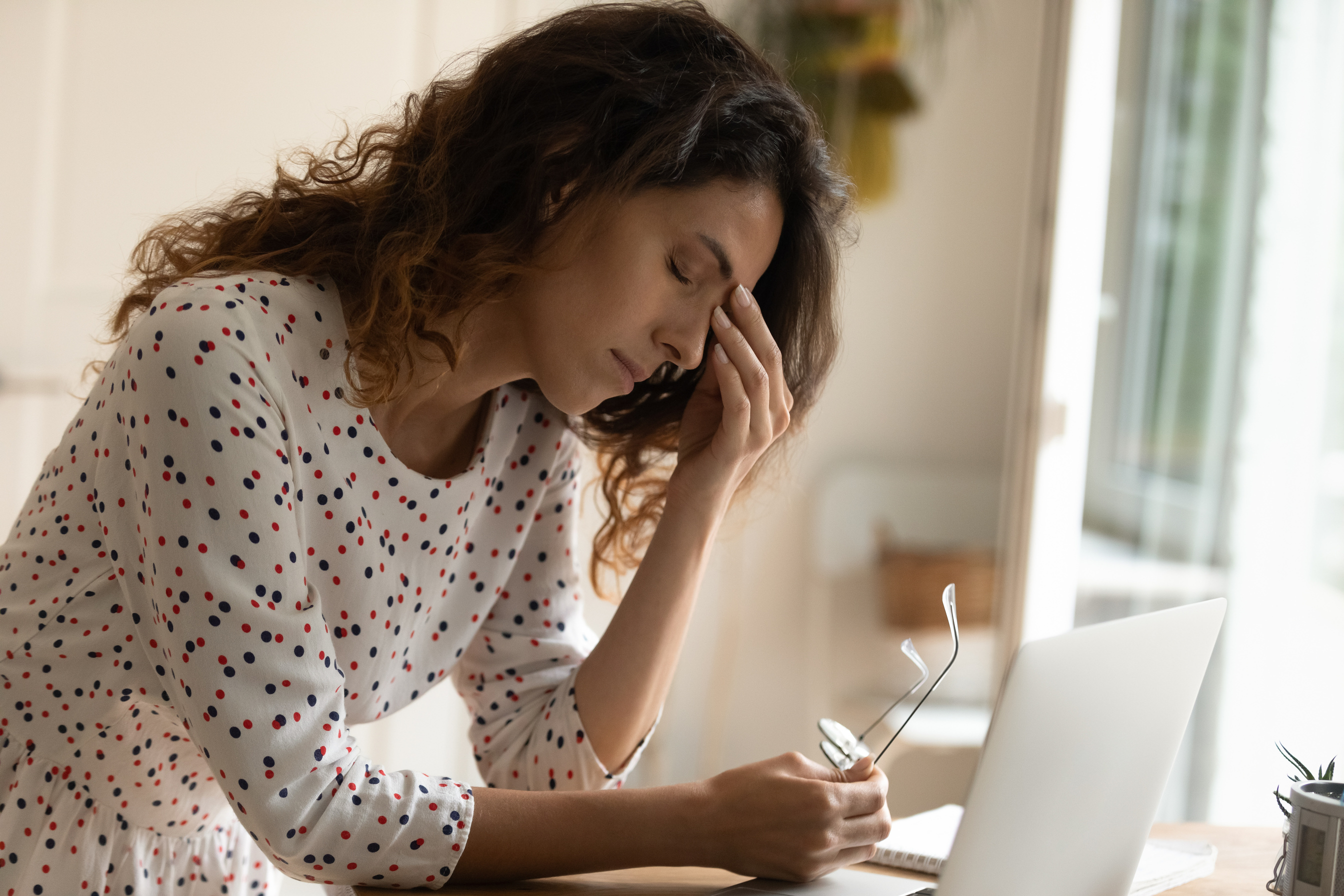 Exhausted woman struggle with headache working on computer